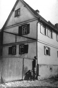 Gestern: Hintergasse 8 um 1911. Vor dem Tor Heinrich u. Wilhelm Roth. Am Fenster Elisabeth Roth. Heute: Alt Langenhain 8, Gesamtrestaurierung mit Plakette prämiert.